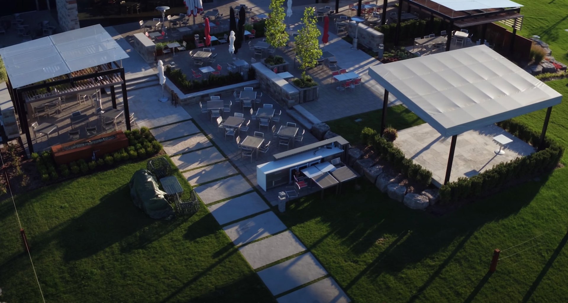 Year-round landscaping maintenance creating beautiful outdoor living spaces Modern outdoor entertainment area with pool, seating areas and landscape lighting