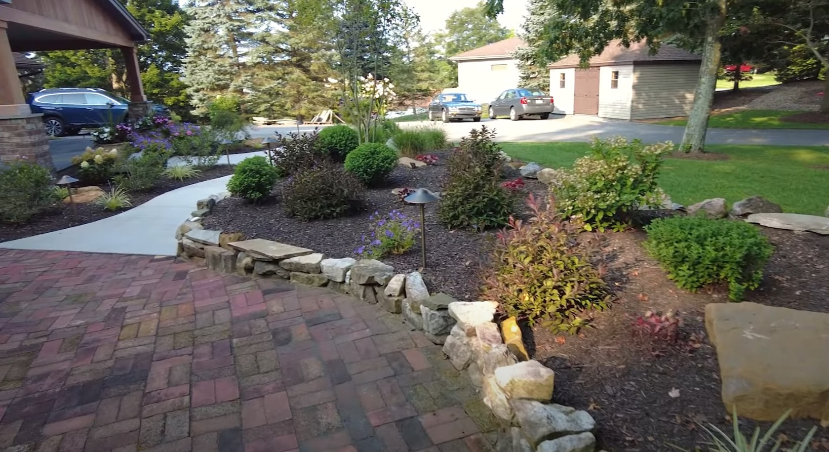 Smart irrigation systems maintaining healthy landscaping and garden beds Residential front yard with professional landscaping including shrubs, flowers and curved garden beds