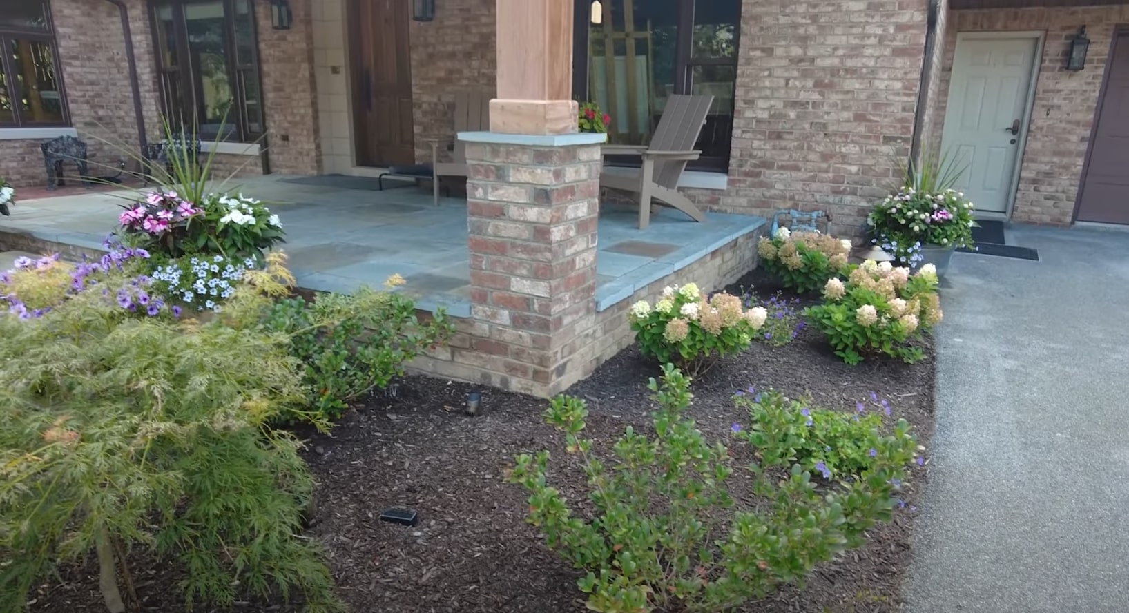 What sets our local landscaping team apart - quality workmanship and attention to detail Modern residential landscaping with brick features, potted plants and professional design